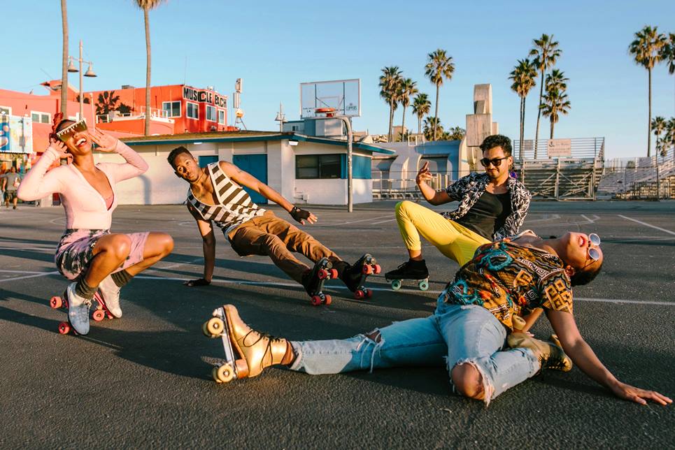 a group of hipsters on rollerskates at the beach