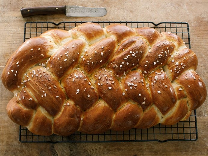 a braided bread, also called challah, with sesame seeds on top.